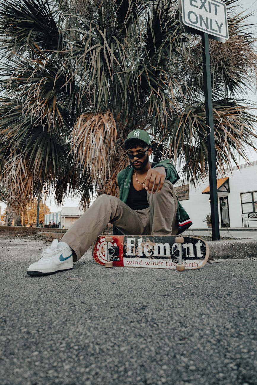 a man sitting on the ground with a skateboard